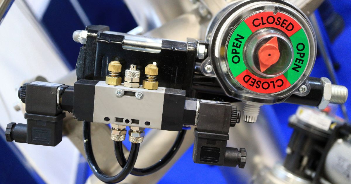 A solenoid valve is attached to a system. The valve has a meter that reads, "Open," in green and, "Closed," in red text.