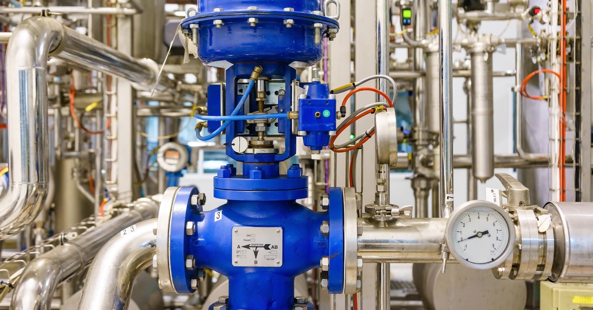 A closeup view of an industrial valve assembly showing labeled open and closed positions on the dial.