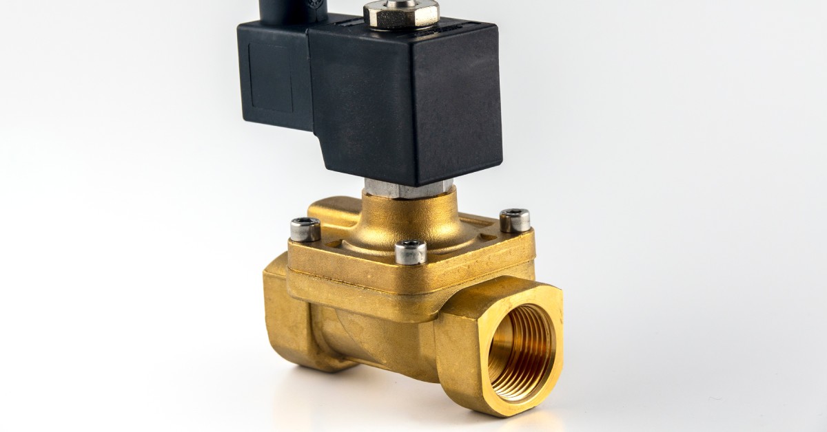 A single solenoid valve sits on a white background. The valve has a brass bottom with a black top.