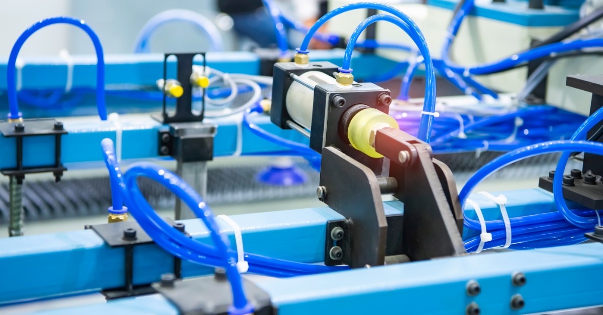 A close-up view shows several long and skinny blue tubes intertwining their way through a blue metal machine.