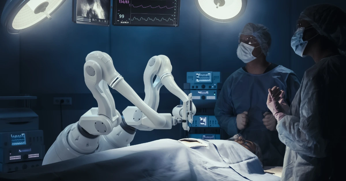 Two surgeons stand in a surgical room looking at monitors. A white surgical arm is ready to operate on the patient.