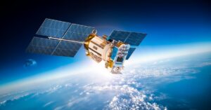 A satellite is floating around in space. Behind the satellite you can see the clouds from Earth's atmosphere.