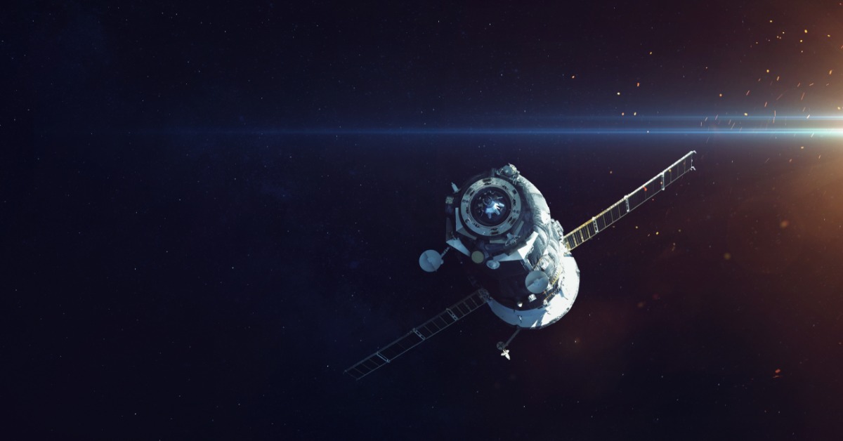 A large satellite is drifting out in the deep, dark space. Something bright illuminates the corner.