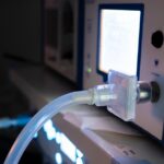 A close-up view shows a laparoscopic insufflator lit up with a clear plastic hose coming out the front.